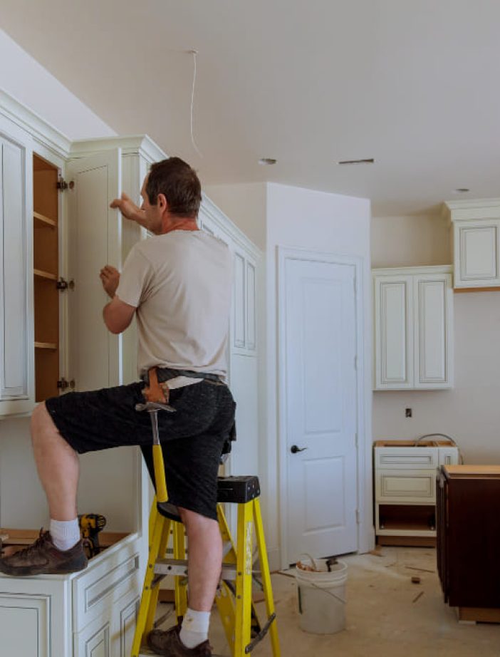 man-installing-kitchen-cabinets-door